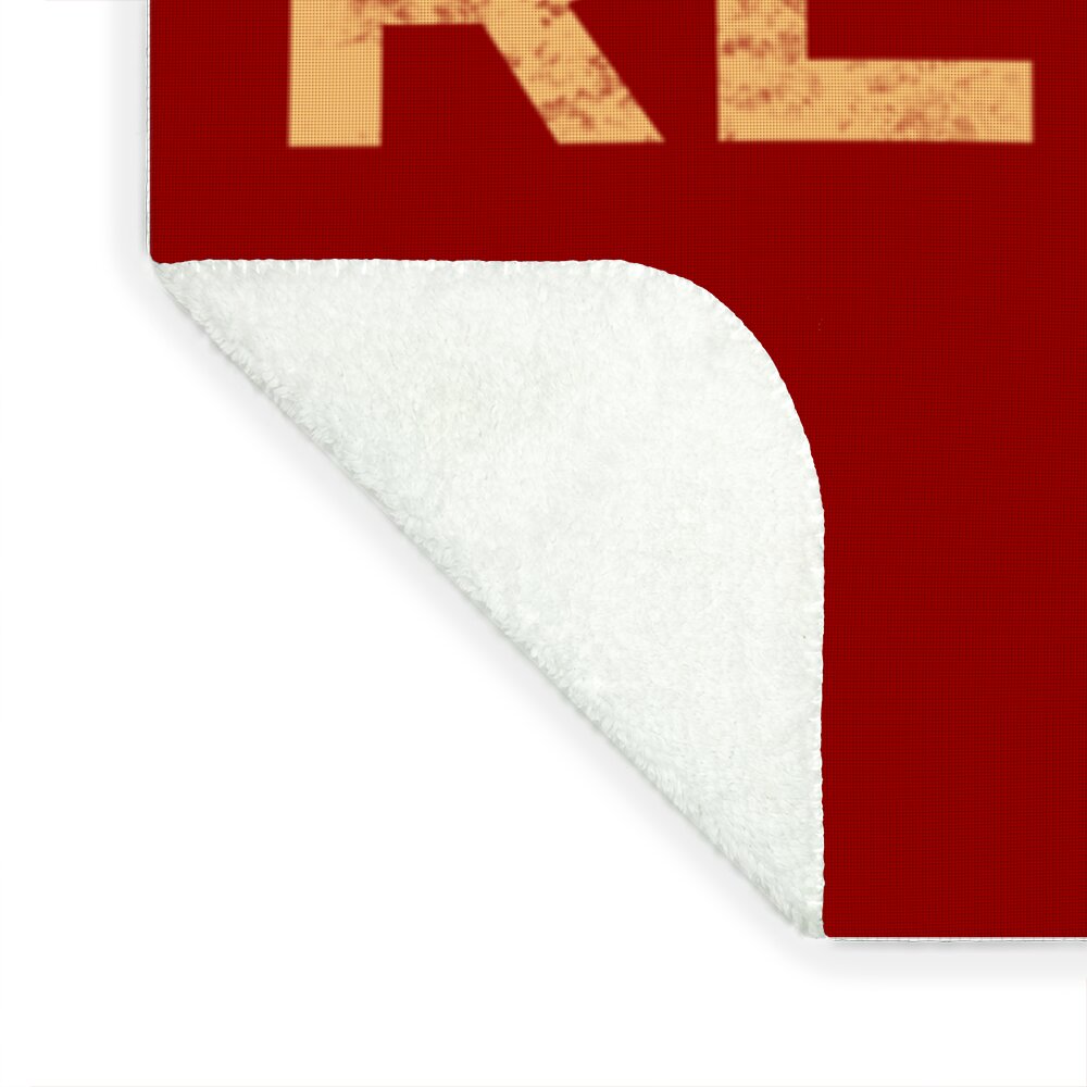 Red blanket corner with white underside and visible stitching along edge.