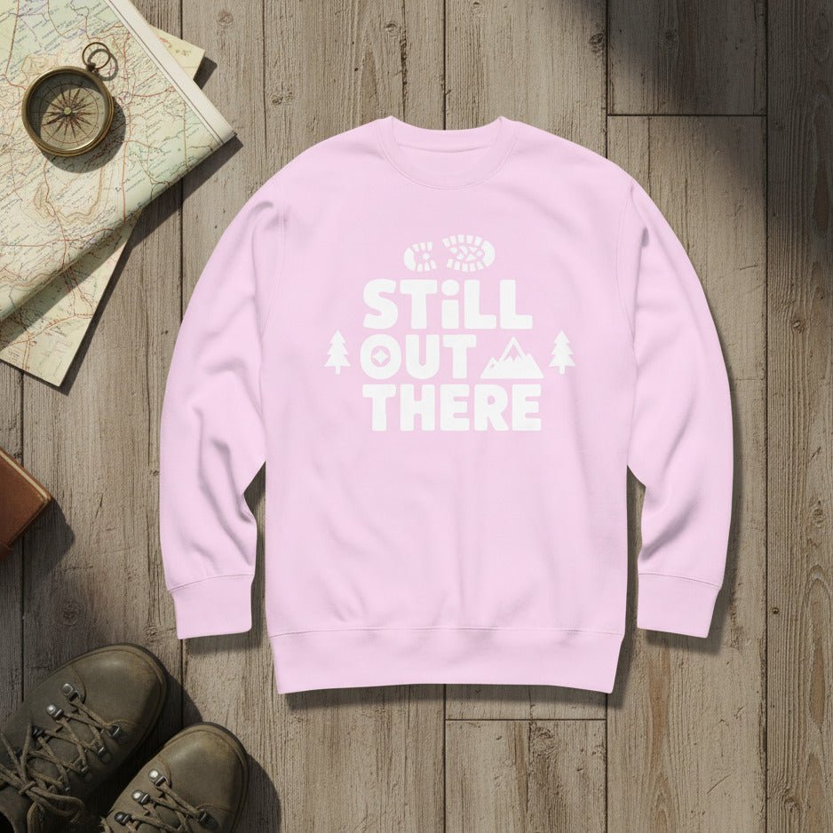Pink hiking sweatshirt with crew neck and white “Still Out There” logo