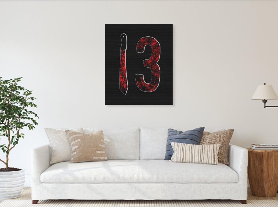Wood print featuring red-splatter number 13 with machete silhouette on black panel.