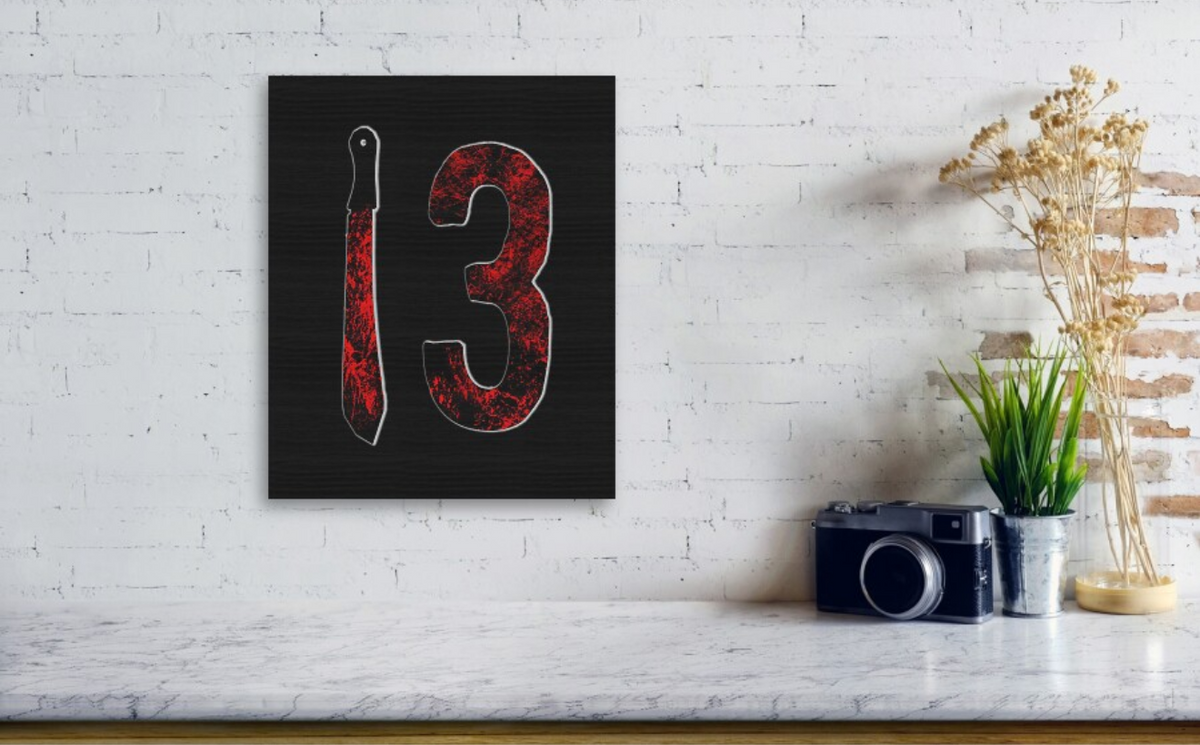 Wood print featuring red-splatter number 13 with machete silhouette, shown as a small wall piece.