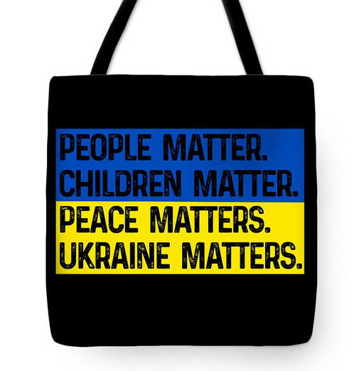 Black tote bag with bold text on blue and yellow flag-style panel, handles included