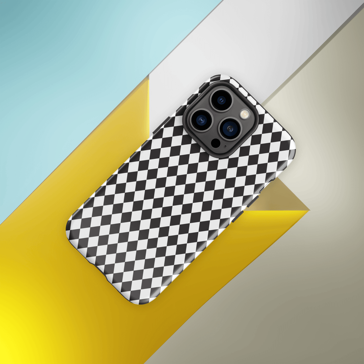 Protective iPhone case with black and white diamond pattern, camera cutouts, angled view from above