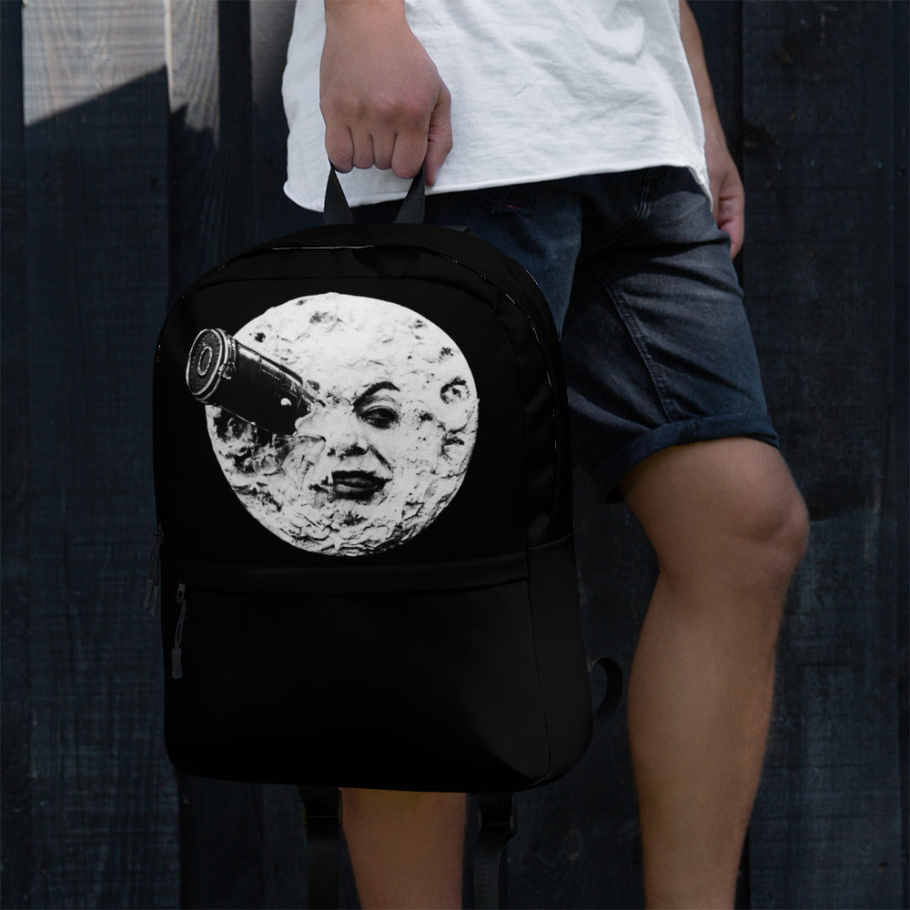 Black backpack with large moon face graphic, front view, held by strap