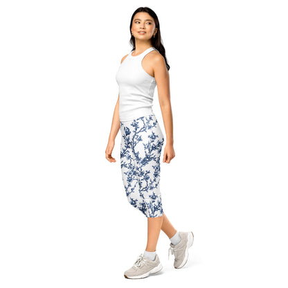 White capri leggings with blue floral print, mid-calf length, worn with sneakers.