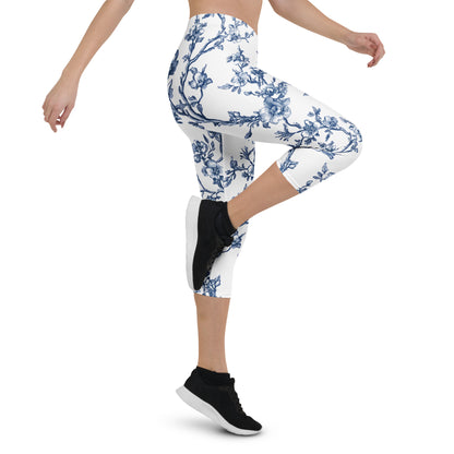 White capri leggings with blue floral vine print, slim fit, mid-calf length.