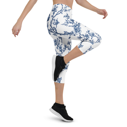 White capri leggings with blue floral vine print, slim fit, mid-calf length.