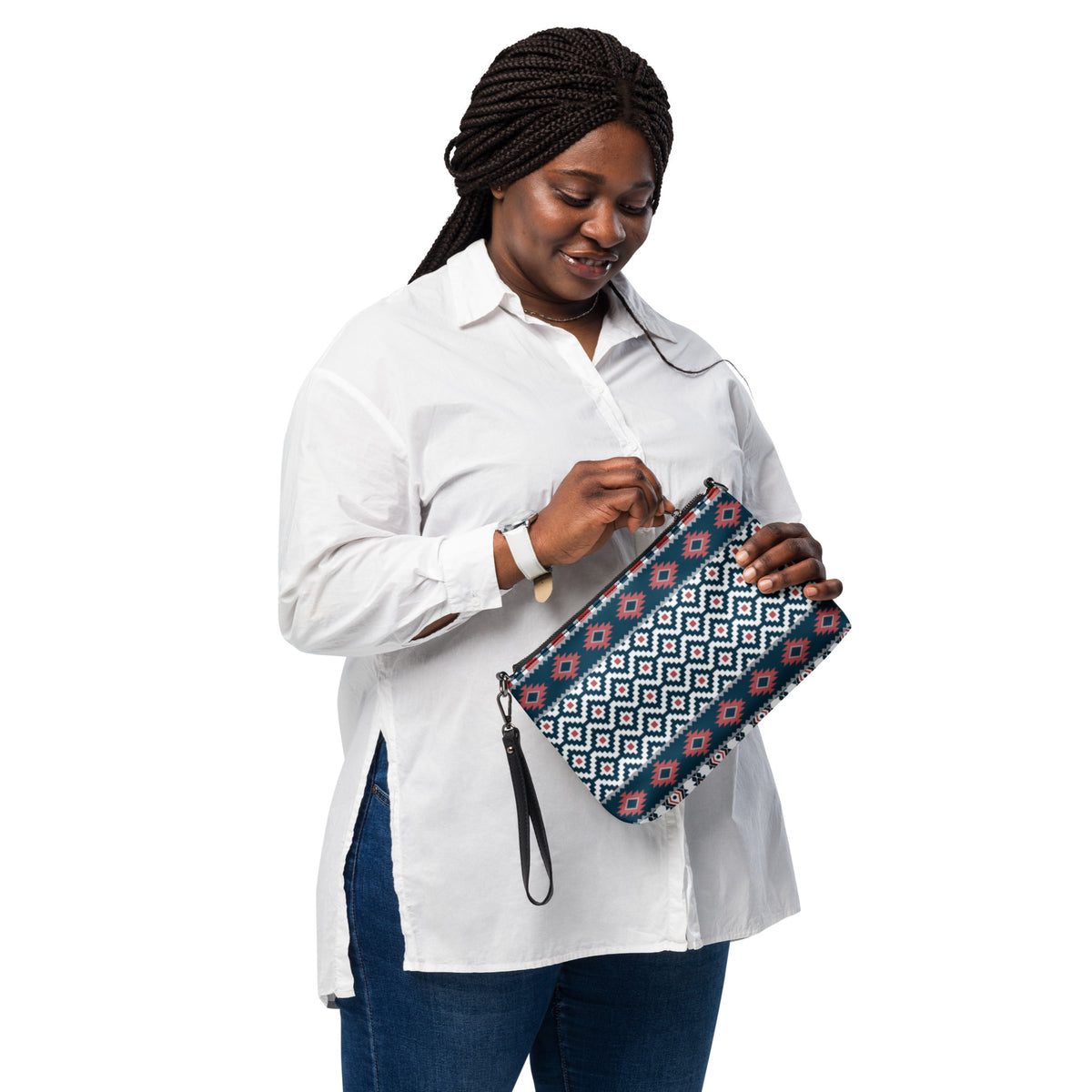Aztec-pattern crossbody bag with brown trim held by a person wearing a white shirt