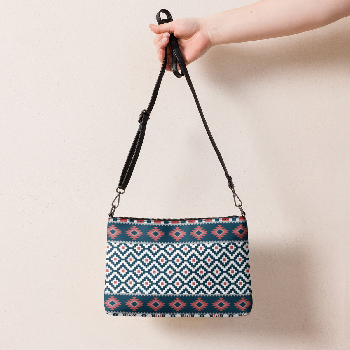 Aztec-pattern crossbody bag hanging with two strap handles and blue-red-white geometric panel