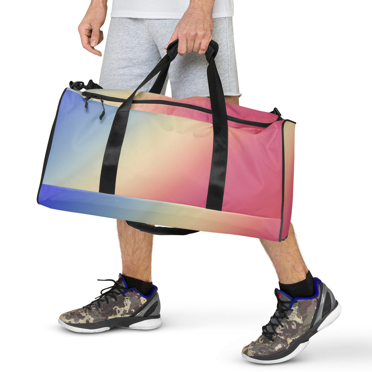 Gradient duffle bag carried by black handles, blue to pink striped design with side mesh pocket