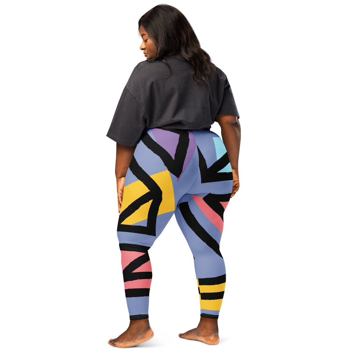 Geometric pattern leggings in blue with black, yellow, and pink shapes from back view