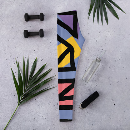 Folded blue geometric leggings with black, yellow, purple, and pink stripe shapes.