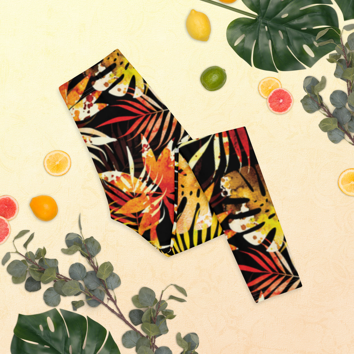 Women's leggings with black base and colorful tropical leaf pattern, close-up