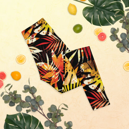Women's leggings with black base and colorful tropical leaf pattern, close-up