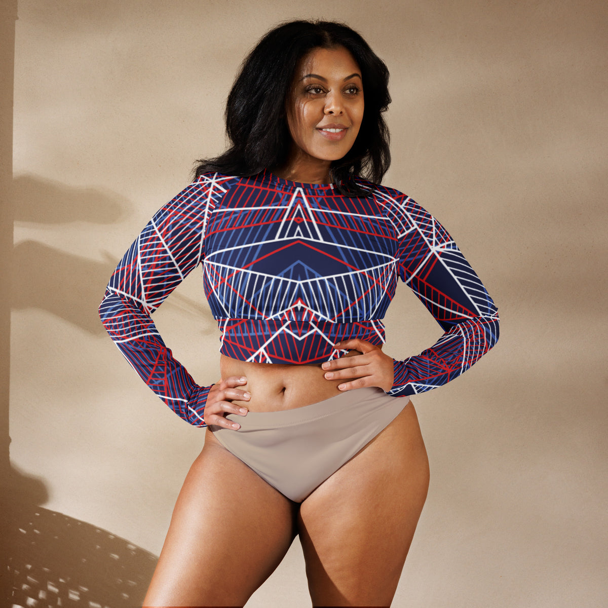 Navy long-sleeve crop top with bold geometric red and white line graphic