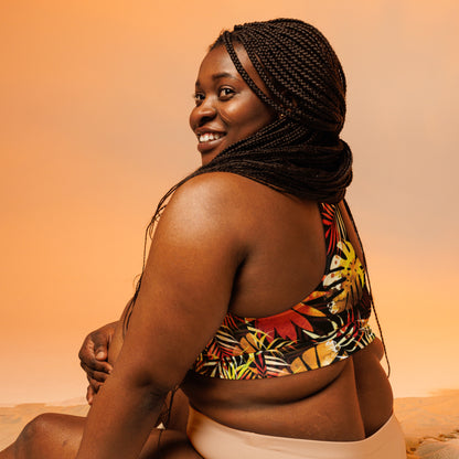 Longline sports bra side view with tropical leaf print, racerback, dark base with red and yellow