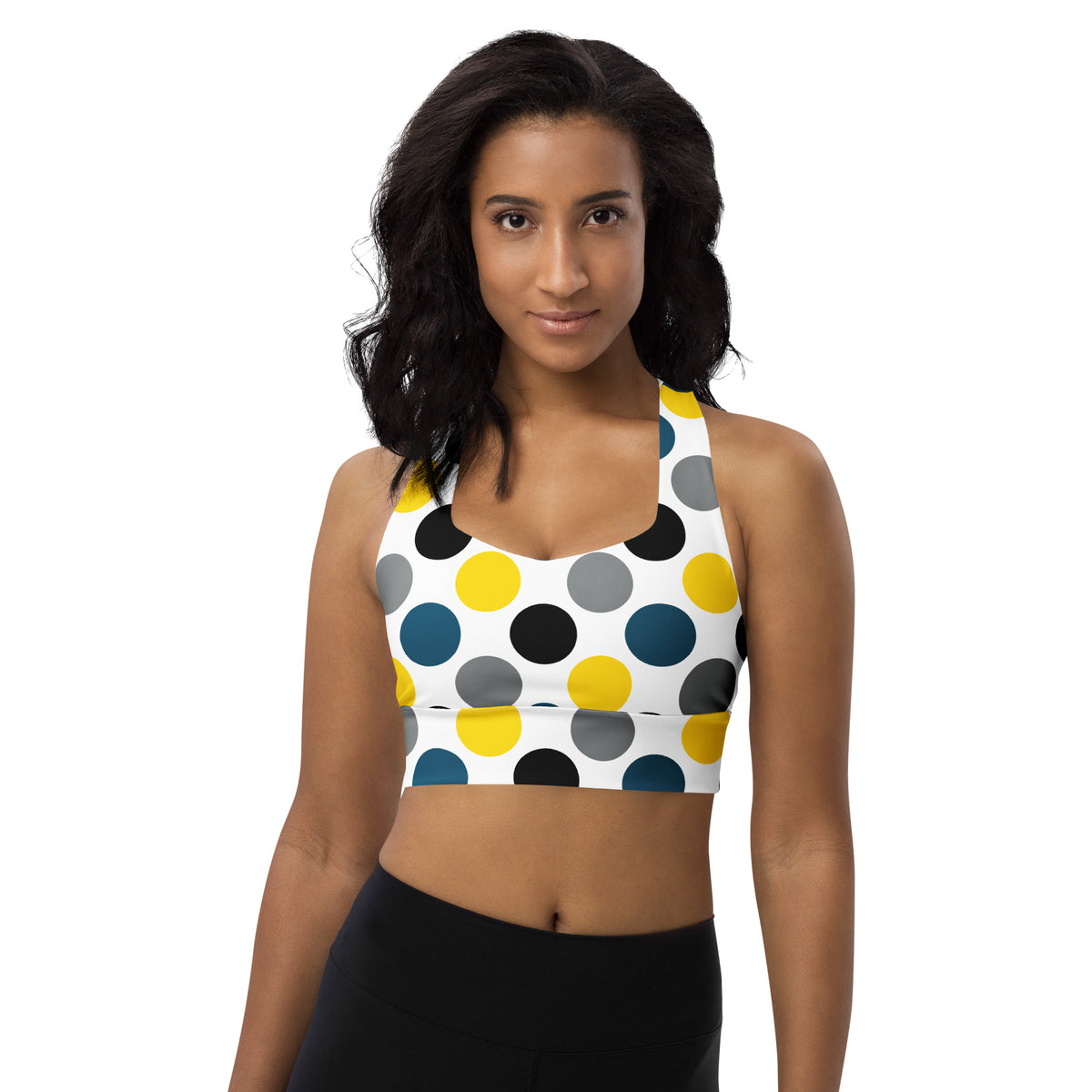 Longline sports bra with white base and multicolor polka-dot print, sleeveless racerback.