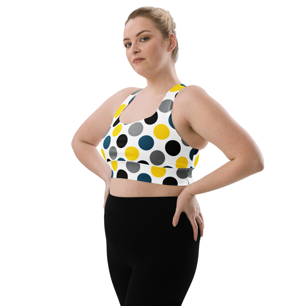 Longline sports bra with white base and multicolor polka-dot print, front view.