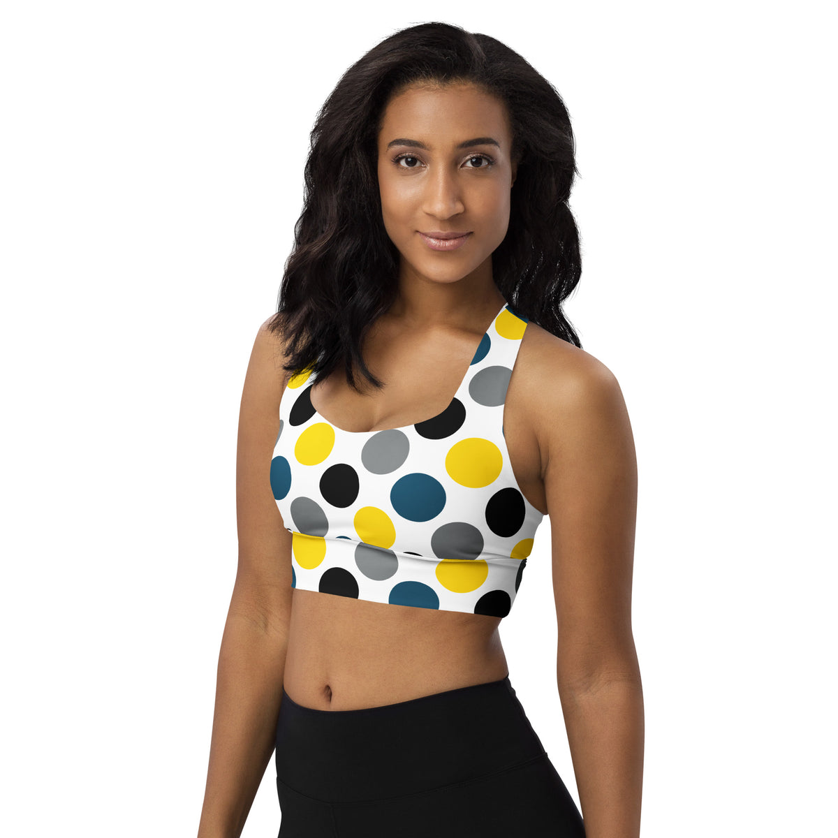 Longline sports bra with white base and multicolor polka-dot print, racerback style.