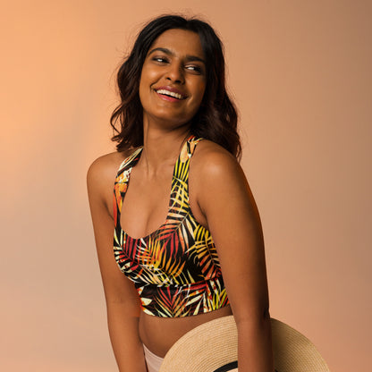 Longline sports bra with tropical leaf print, racerback straps on black with red, yellow, and green
