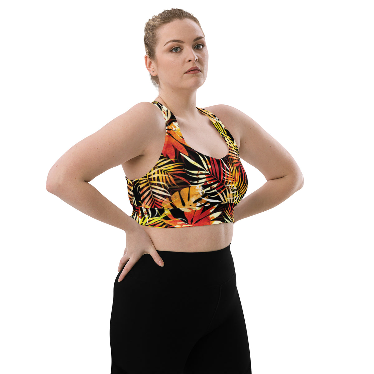 Longline sports bra with tropical leaf print, sleeveless scoop neck on black with red and yellow accents