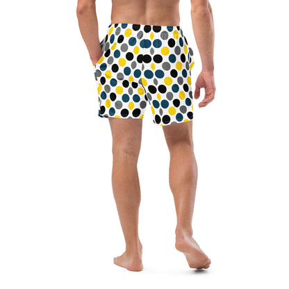Polka dot swim trunks in white with blue, yellow, and black dots, mid-length