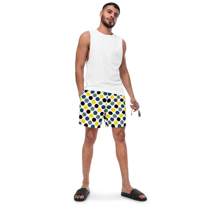 Polka dot swim trunks in white with blue, yellow, and black dots, mid-length