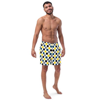 Polka dot swim trunks in white with blue, yellow, and black dots, mid-length