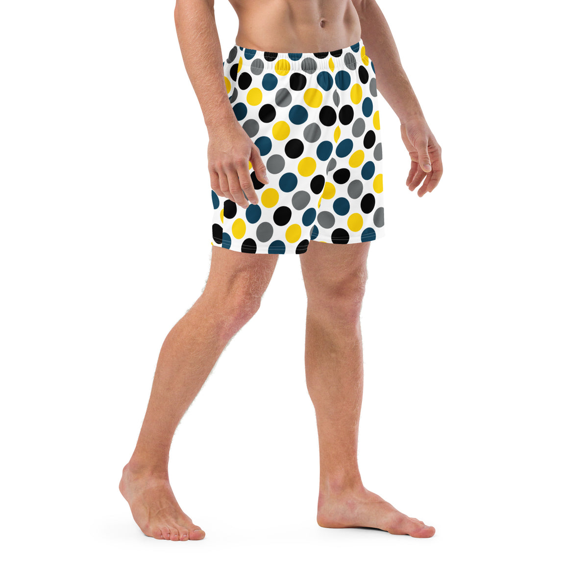 Side view polka dot swim trunks in white with blue, yellow, and black dots