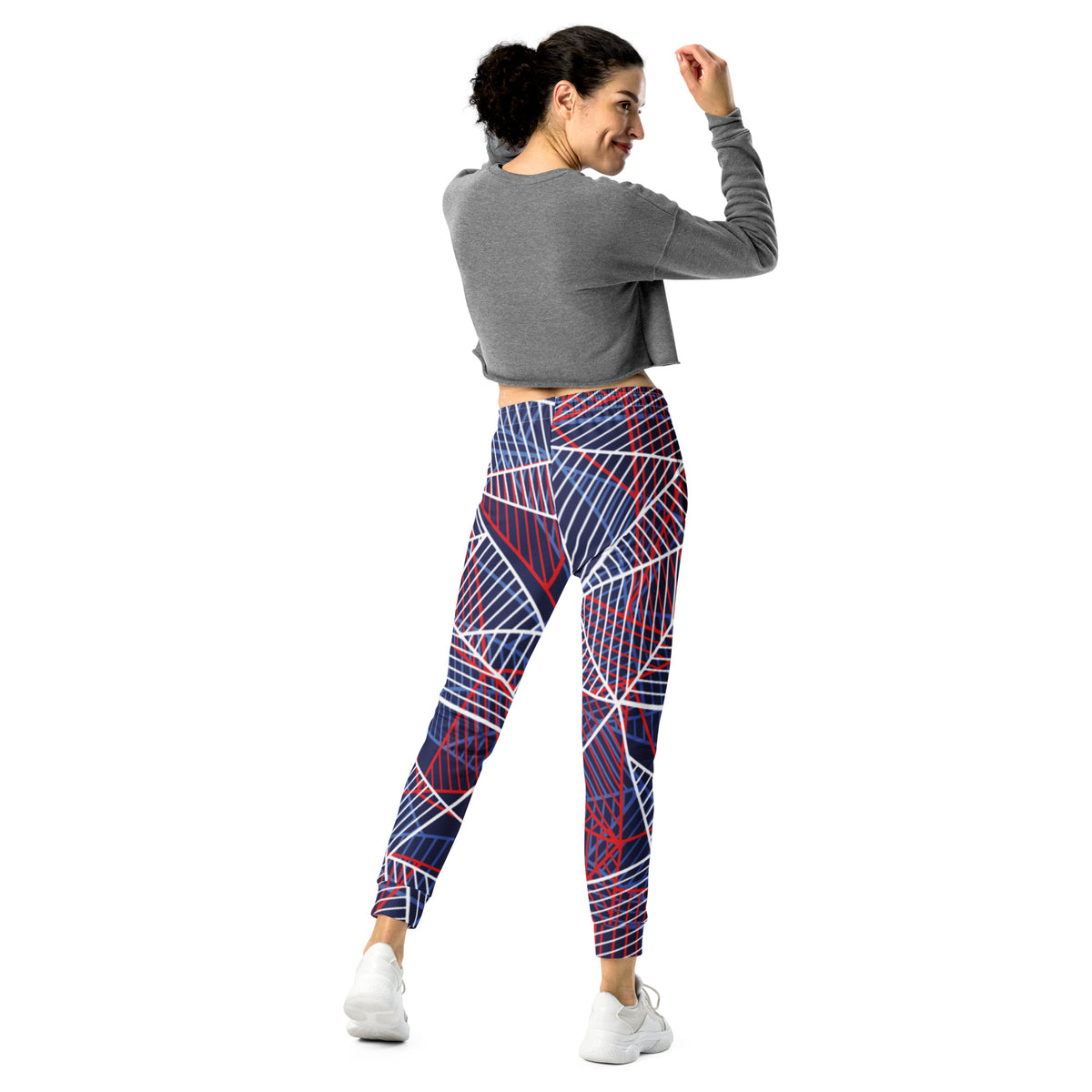Women’s jogger pants with bold abstract line design on navy base and red-white details.