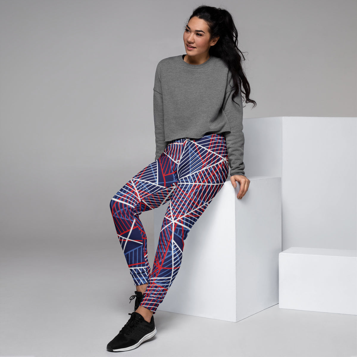 Women’s joggers with colorful abstract line print, navy base and red-white accents.