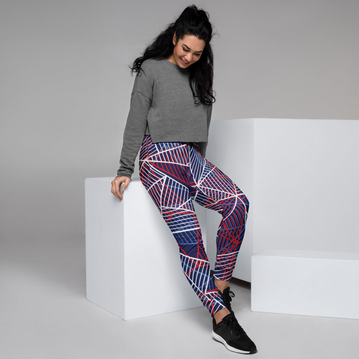 Women’s abstract line joggers in navy with red and white geometric stripe pattern.