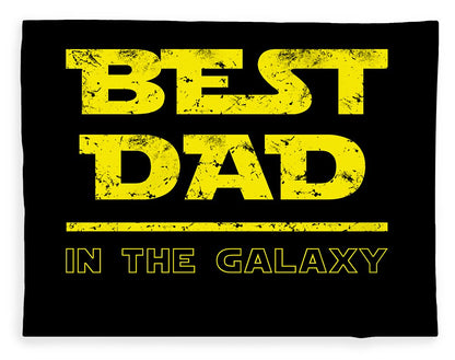 Black blanket featuring large yellow “BEST DAD” lettering and “IN THE GALAXY” below