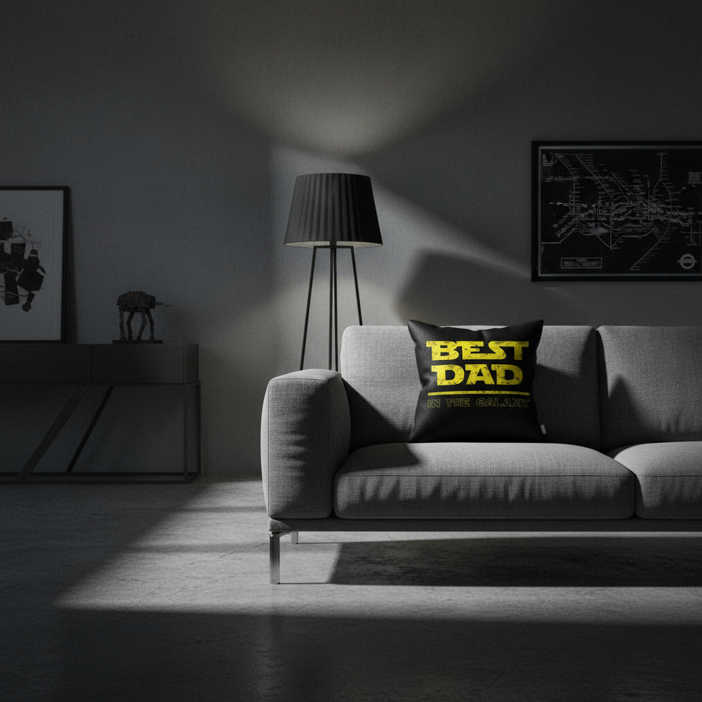 Throw pillow on gray sofa, black cover with yellow 'BEST DAD IN THE GALAXY' print