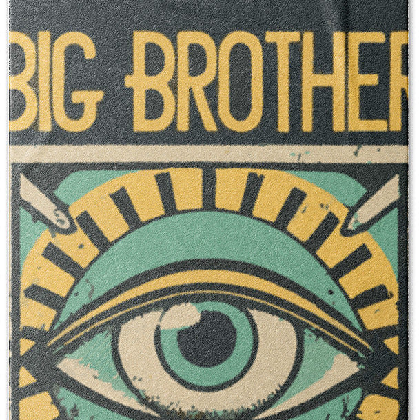 Dark bath towel close-up of green eye graphic with yellow lettered text.
