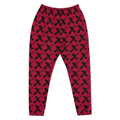 Men's red joggers with black X pattern, front view with tapered ankle cuffs