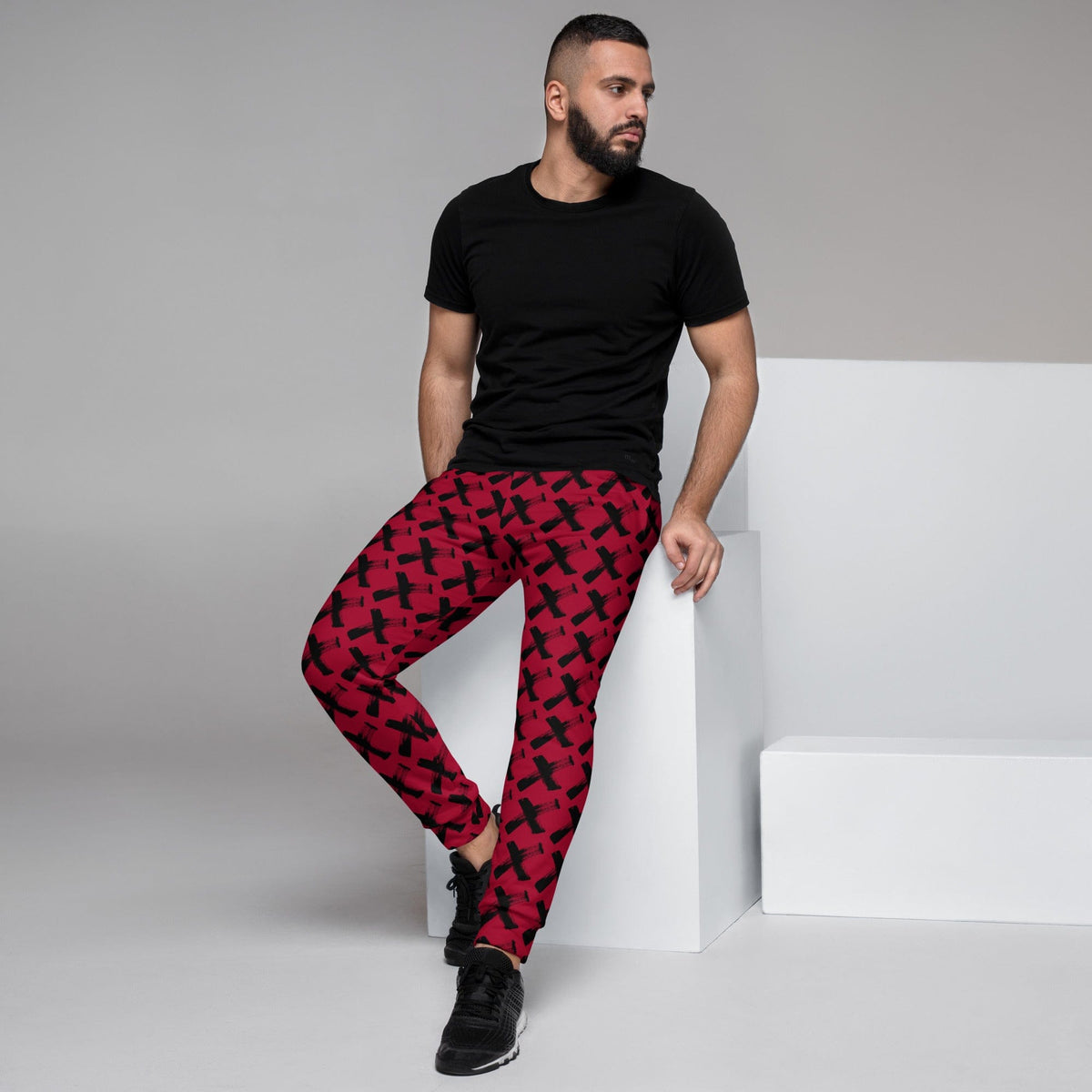 Men's red joggers with black X pattern, slim fit and elastic ankle cuffs
