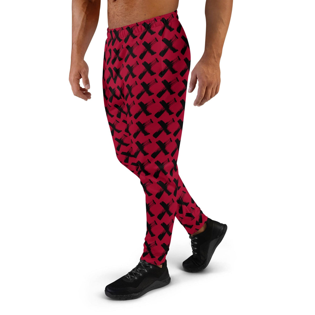 Men's red joggers with black X pattern, close side view of full-length legs