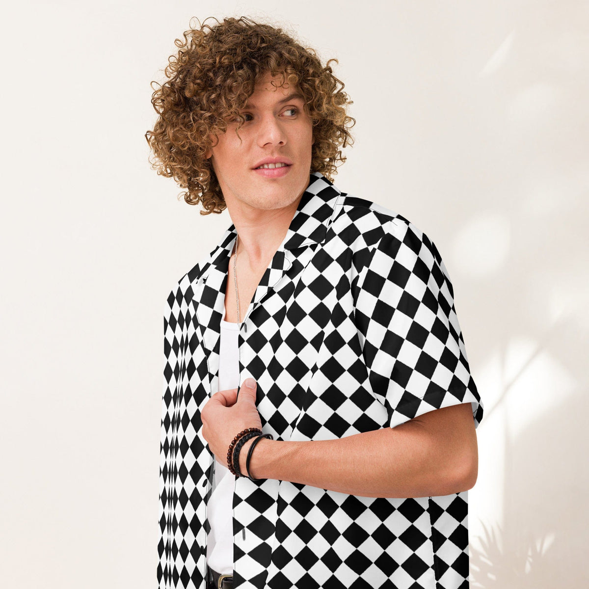 Unisex short-sleeve button shirt with black-and-white check pattern, worn open at the neck.