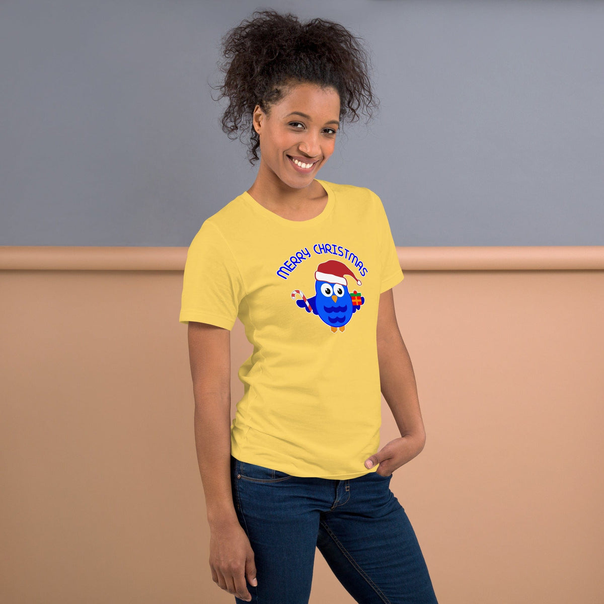 Christmas owl graphic T-shirt in yellow with blue cartoon owl and “Merry Christmas” text.
