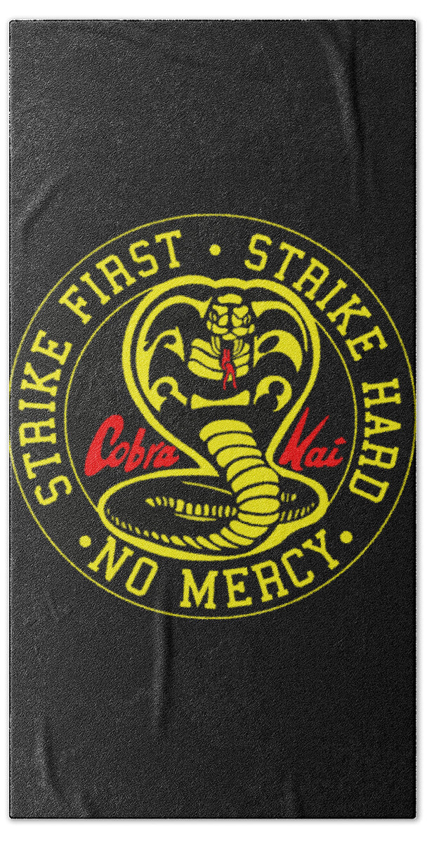 Beach towel, dark; round Cobra Kai "Strike First" emblem with "No Mercy" text