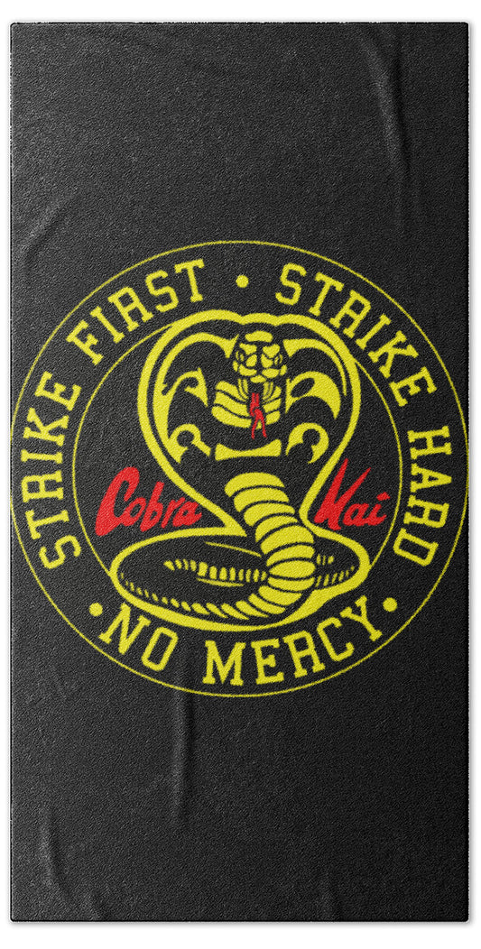 Beach towel, dark; round Cobra Kai "Strike First" emblem with "No Mercy" text