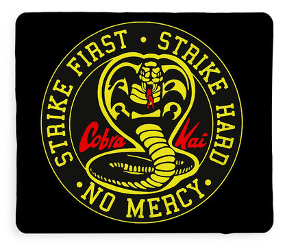 Black throw blanket with yellow circular logo, coiled cobra illustration, and ring text