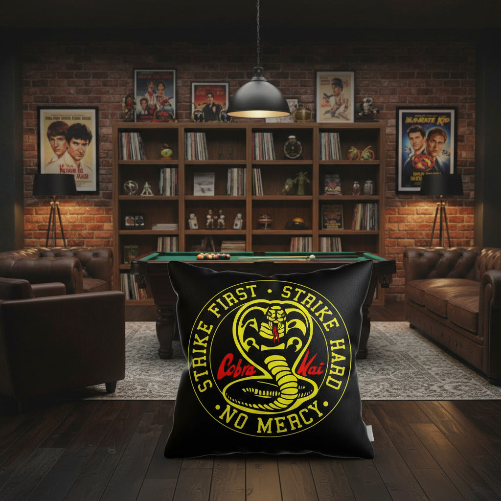 Black throw pillow with large circular Cobra Kai Strike First logo in yellow and red