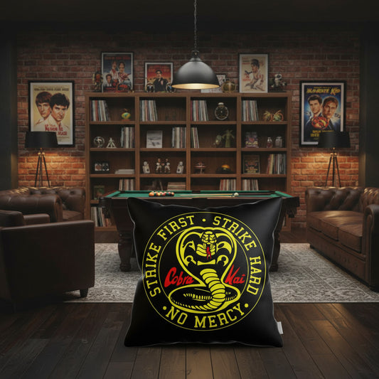 Black throw pillow with large circular Cobra Kai Strike First logo in yellow and red