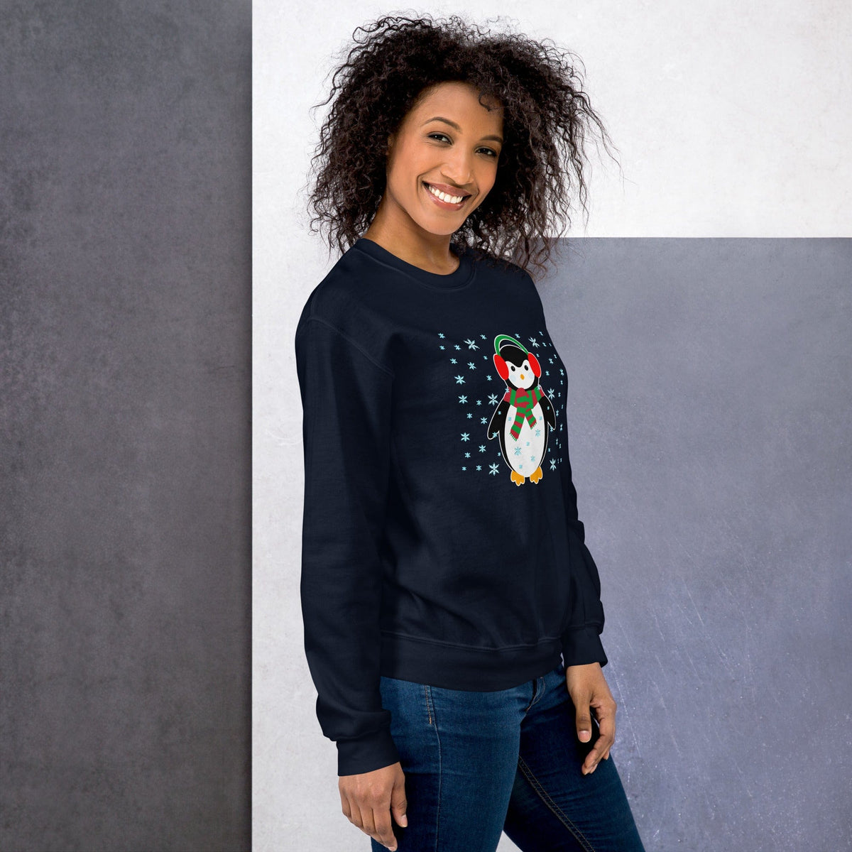 Navy crewneck sweatshirt with long sleeves and a penguin graphic with snowflakes