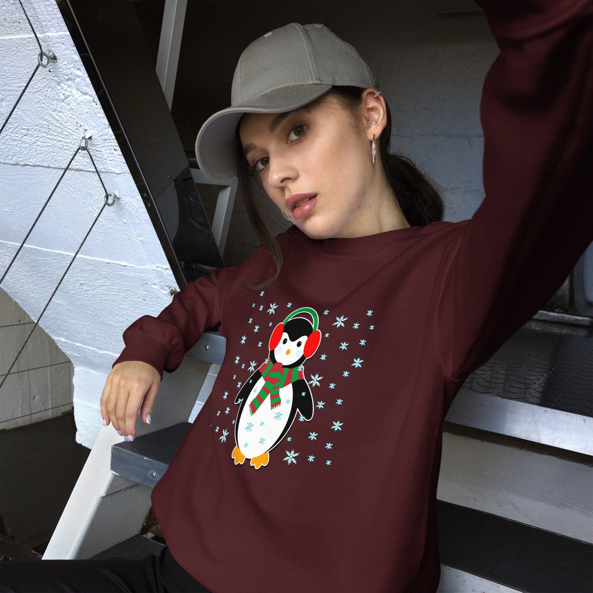 Maroon crewneck sweatshirt with long sleeves and a penguin graphic with snowflakes