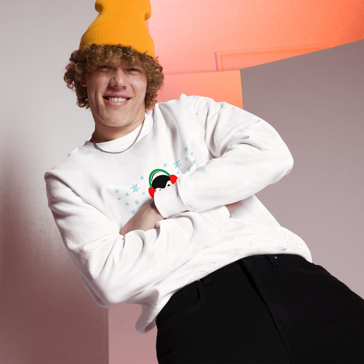 White sweatshirt with long sleeves and a colorful penguin graphic with blue snowflakes.