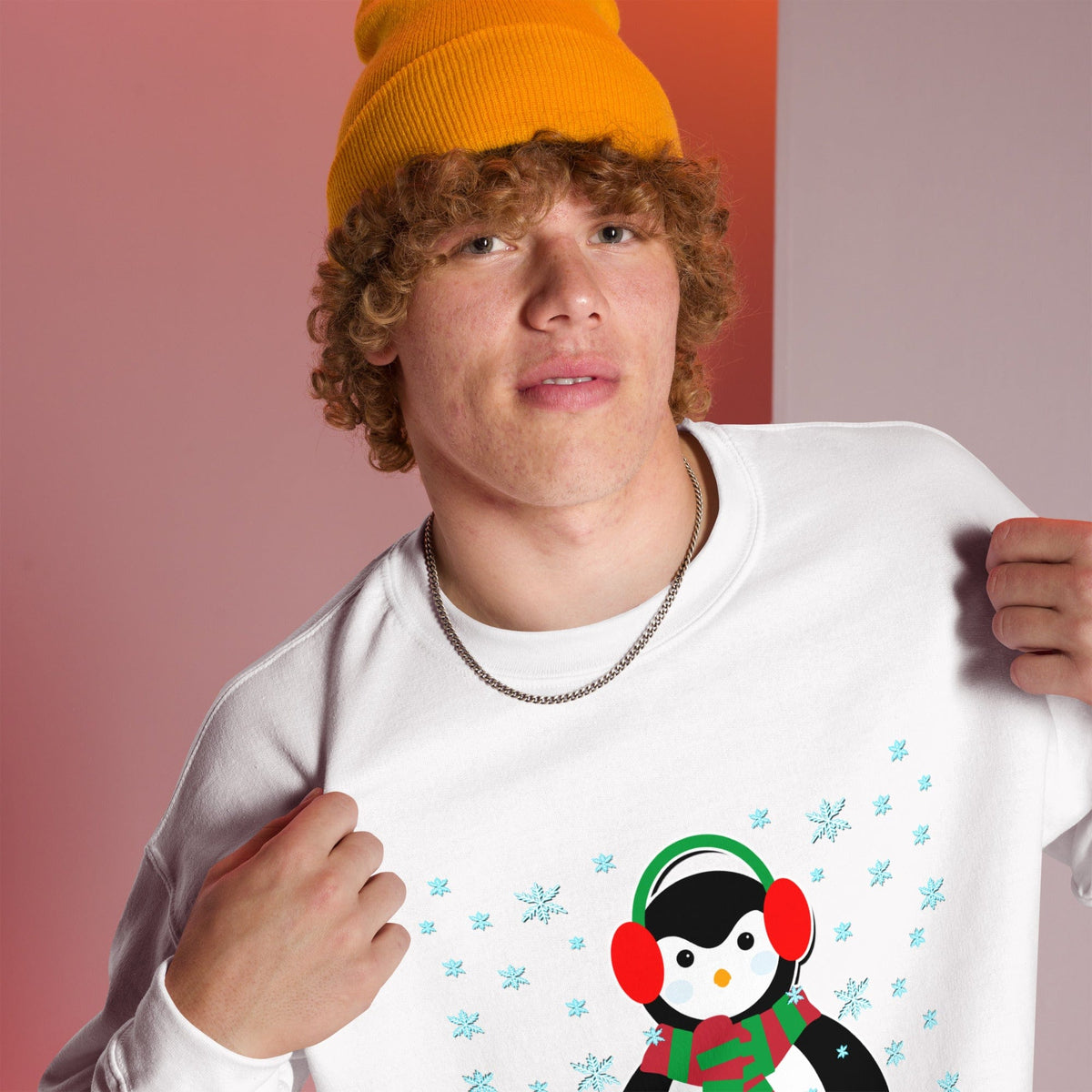 White sweatshirt with long sleeves and a colorful penguin graphic with blue snowflakes.