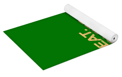 Green yoga mat laid flat, roll end showing "EAT. SLEEP." lettering