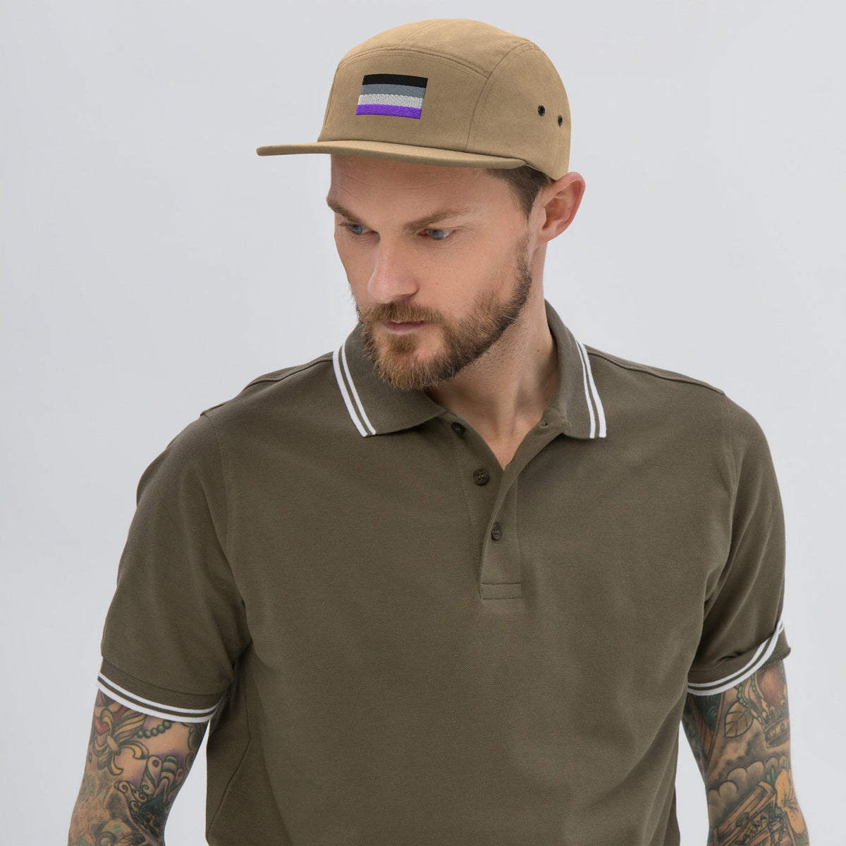 Khaki five-panel cap with embroidered asexual flag patch and curved brim